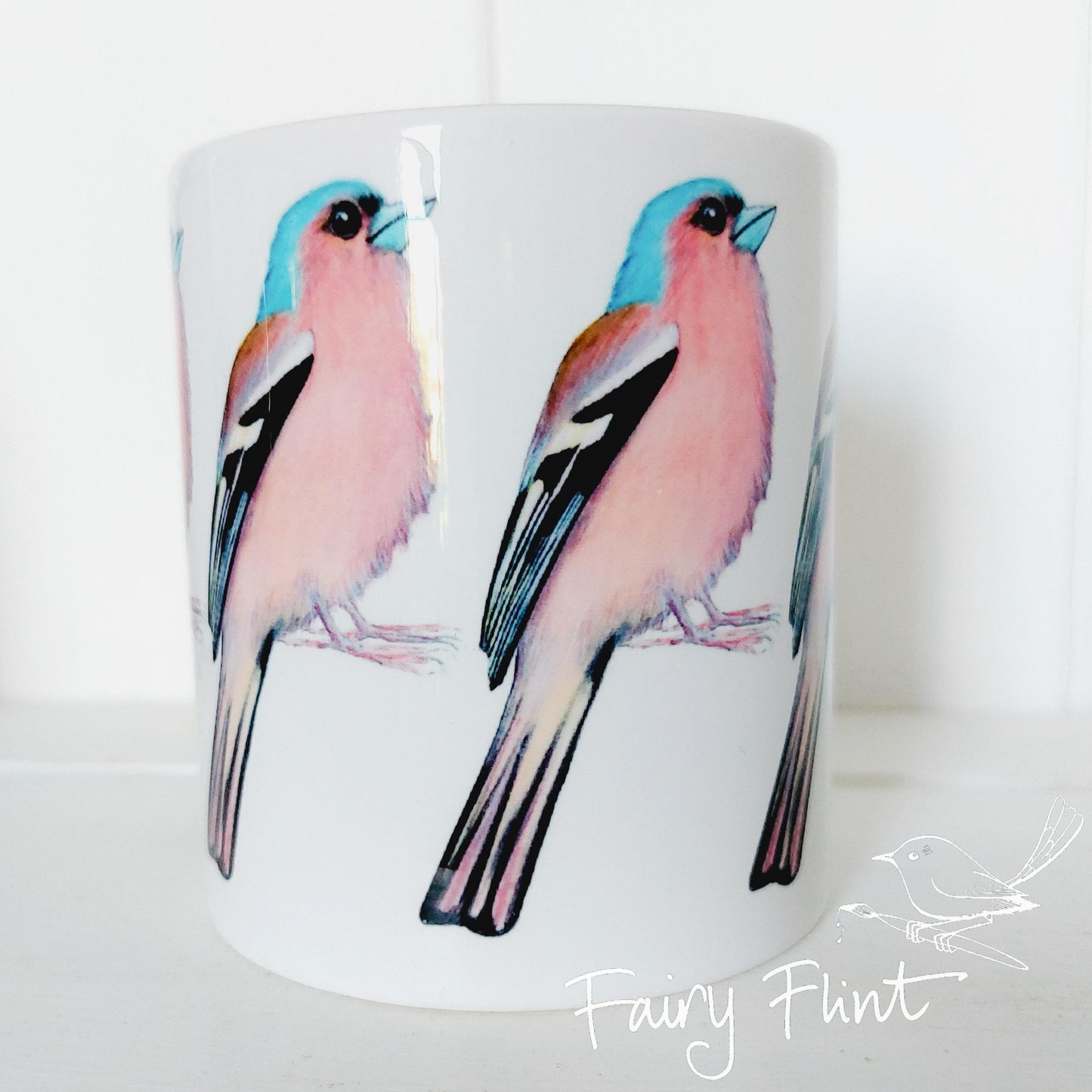 Ceramic mug with Chaffinch painting by Fairy Flint repeated round the mug, printed withy eco friendly inks