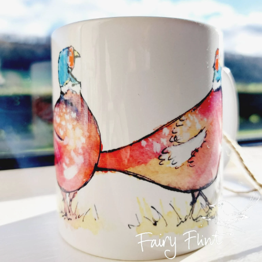 Ceramic mug with Pheasant painting design by Fairy Flint photoshoot at Eaton Manor Shropshire Wenlock Edge behind mug