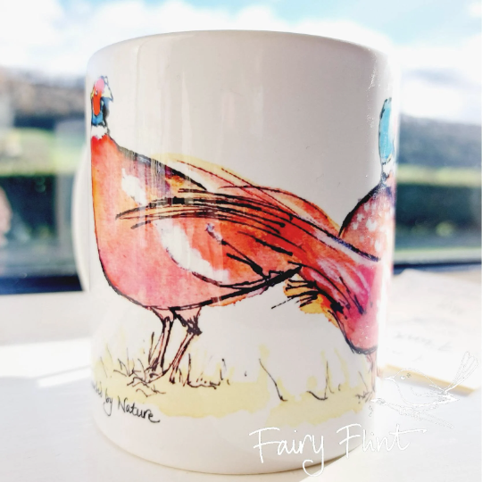 Ceramic mug with Pheasant painting design by Fairy Flint photoshoot at Eaton Manor Shropshire Wenlock Edge behind mug