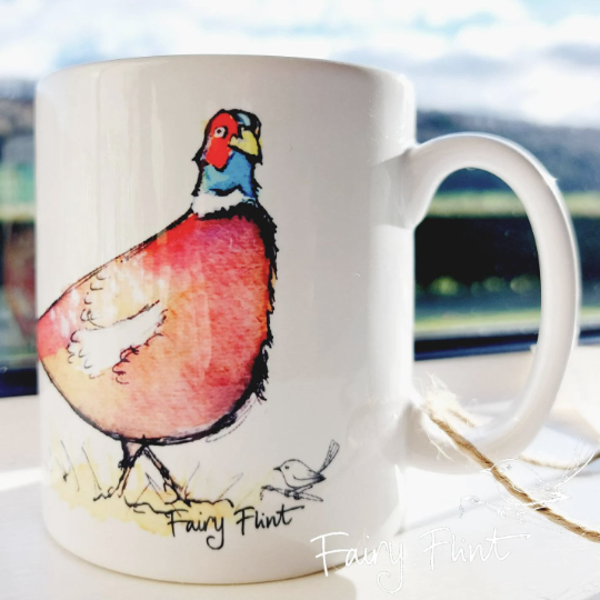 Ceramic mug with Pheasant painting design by Fairy Flint photoshoot at Eaton Manor Shropshire Wenlock Edge behind mug