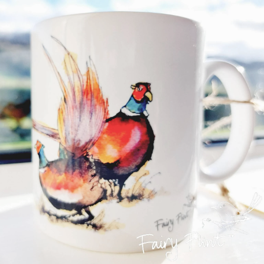 Ceramic mug with eco print of a fun Pheasant painting design by Fairy Flint photoshoot at Eaton Manor Shropshire, Wenlock Edge behind the mug