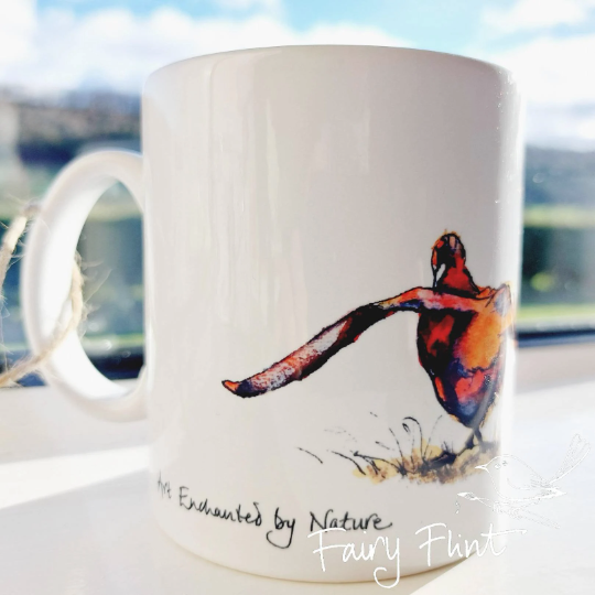 Ceramic mug with eco print of a fun Pheasant painting design by Fairy Flint photoshoot at Eaton Manor Shropshire, Wenlock Edge behind the mug