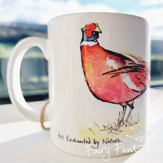 Ceramic mug with Pheasant painting design by Fairy Flint photoshoot at Eaton Manor Shropshire Wenlock Edge behind mug