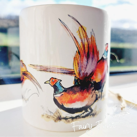 Ceramic mug with eco print of a fun Pheasant painting design by Fairy Flint photoshoot at Eaton Manor Shropshire, Wenlock Edge behind the mug